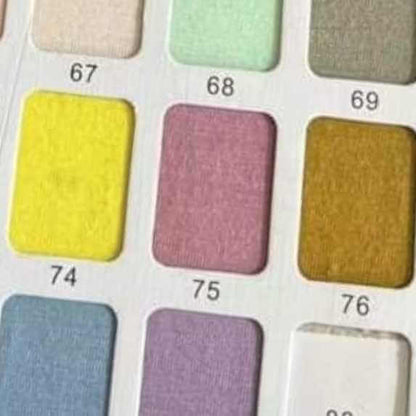 Palette of fabric swatches with various shades including celadon green, representing Wren Ivy Co.'s range of colors for bamboo baby clothing.